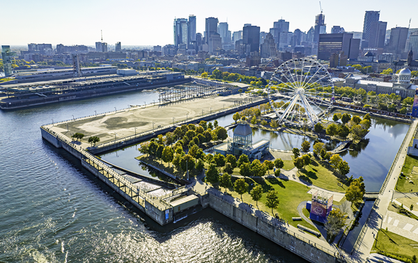 Vue aérienne du Vieux-Port de Montréal avec la grande roue au premier plan et la skyline de la ville en arrière plan.