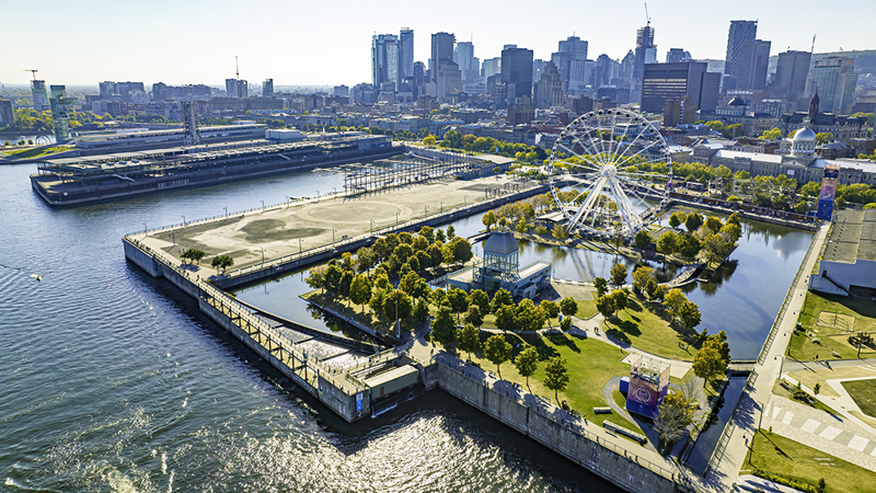 Vue aérienne du Vieux-Port de Montréal avec la grande roue au premier plan et la skyline de la ville en arrière plan.