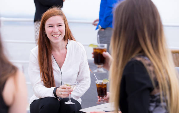 Amies qui discute sur la terrasse avec un verre à la main