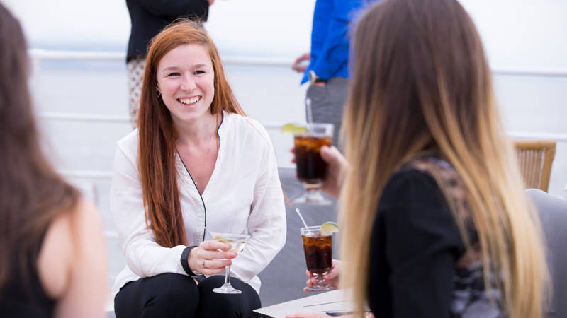 Amies qui discute sur la terrasse avec un verre à la main