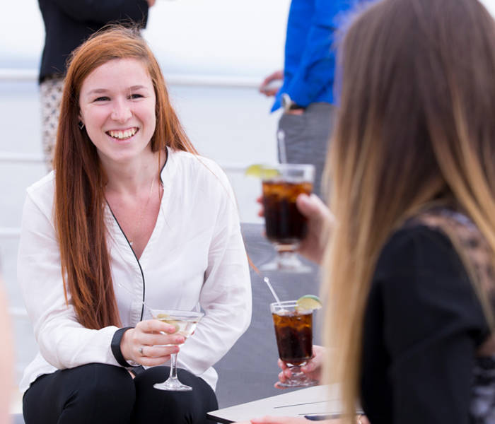 Amies qui discute sur la terrasse avec un verre à la main