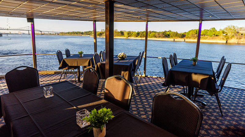 Salle intérieure avec des tables avec la vue sur le Saint-Laurent