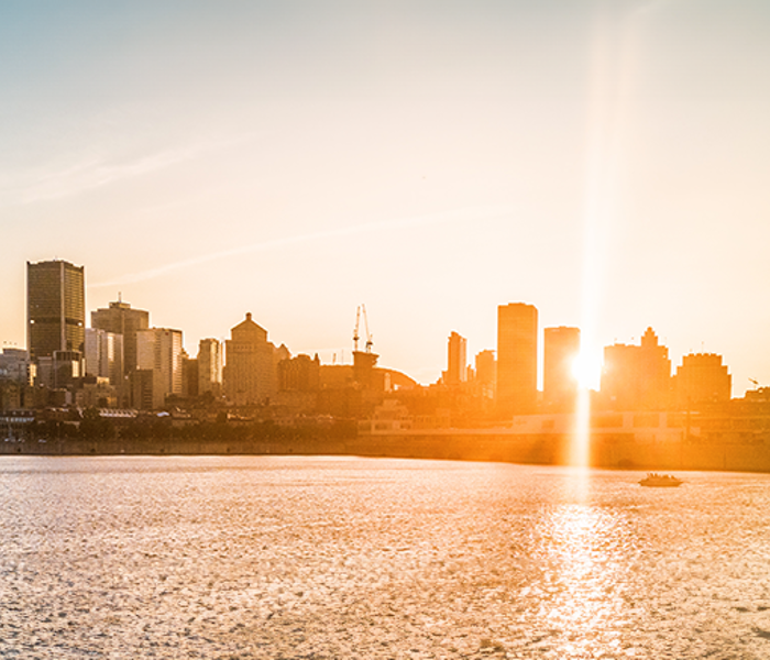 Un coucher de soleil projetant une lueur chaleureuse sur la skyline de Montréal.