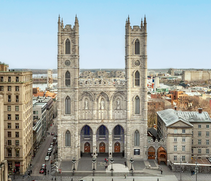 Basilique Notre-Dame de Montréal avec en premier plan la place d'Armes et quelques immeubles de Montréal