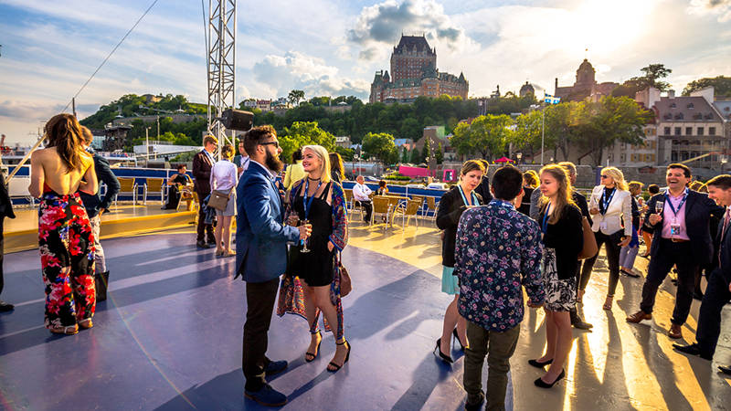 Groupe de personne profitant de l'une des terrasses extérieures du navire AML Louis Jolliet avec une vue imprenable sur Québec et le Château Frontenac 