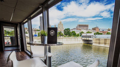 View from a table and chairs on board the AML Cavalier Maxim ship in Montreal, with a view of the city from a window